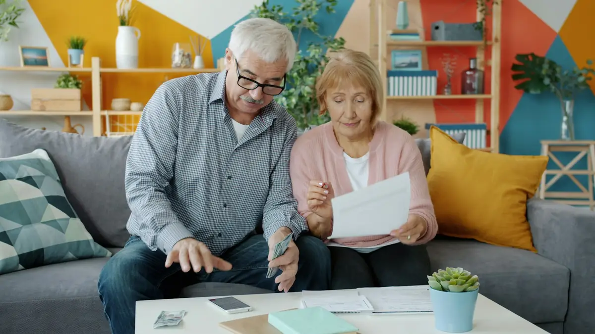Couple de retraités examinant des papiers à la maison