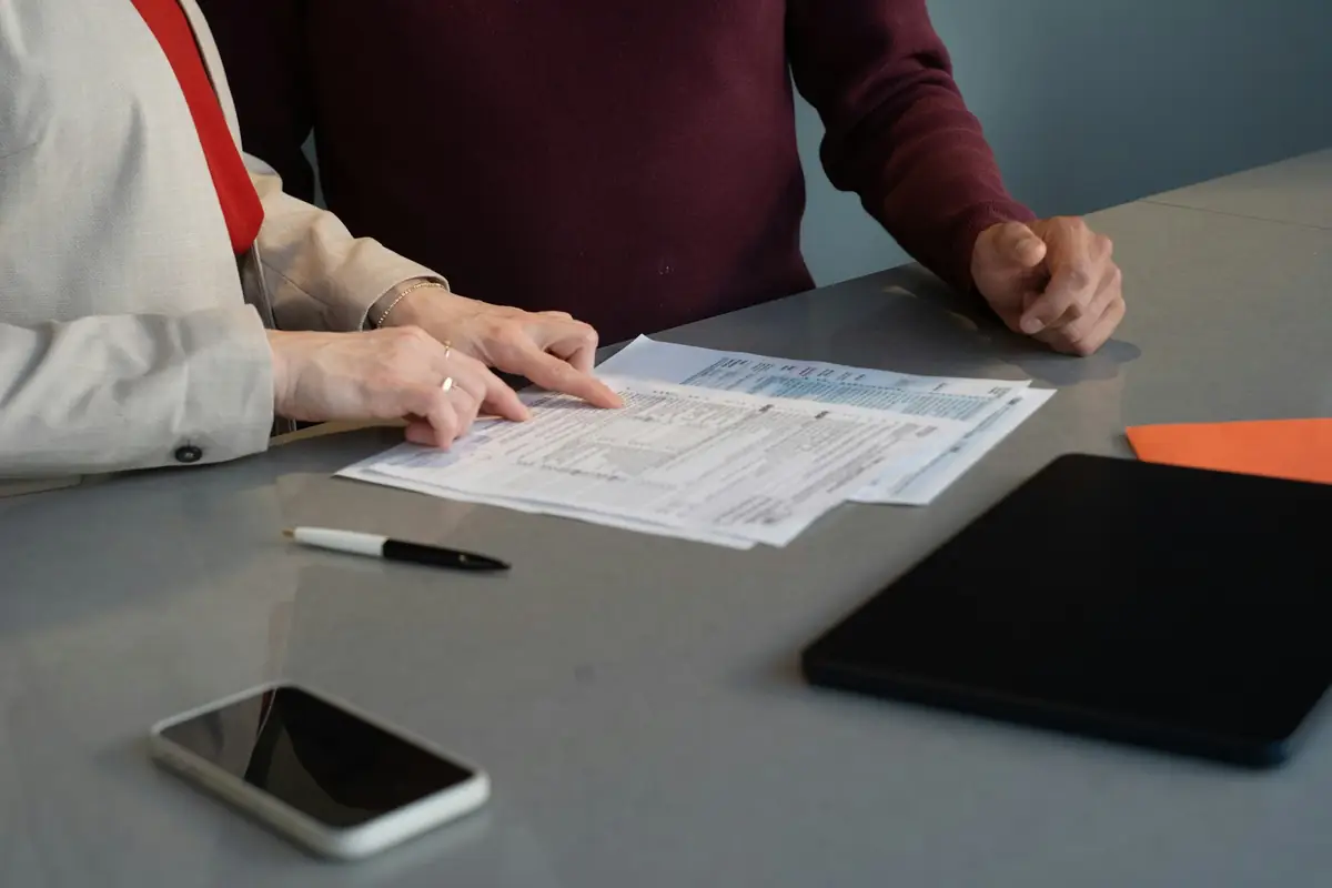 Deux personnes examinent des documents autour d'une table
