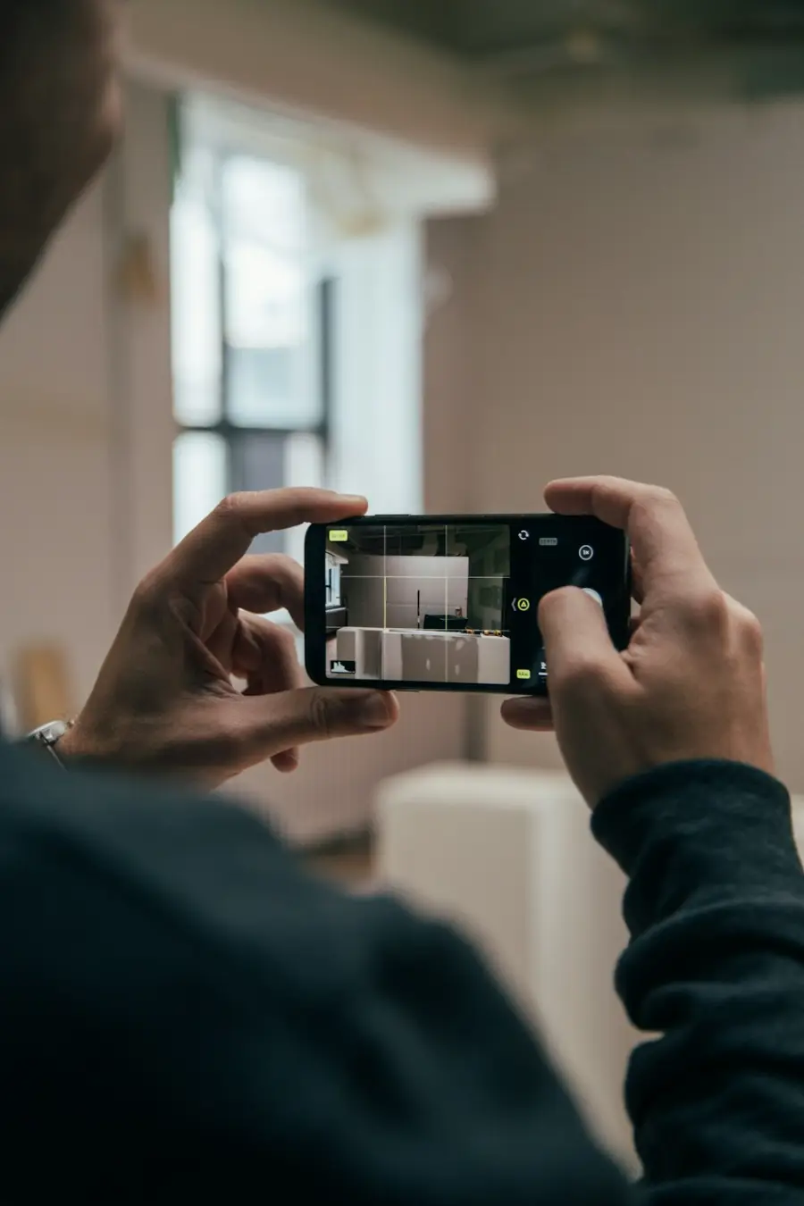 Mains qui photographient un intérieur avec un smartphone